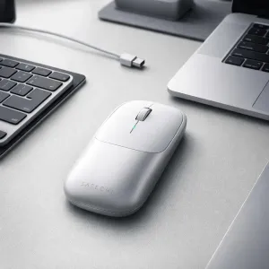 Satechi Slim EX trådløs mus i sølv på et skrivebord ved siden av en bærbar PC og et tastatur