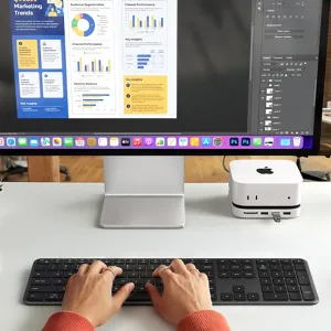 Satechi EX3 Slim bezvadu tastatūra melnā krāsā ar Ziemeļvalstu izkārtojumu, novietota uz galda, kamēr rokas raksta