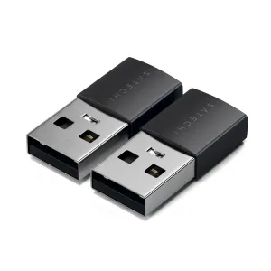 Divi Satechi USB-A uz USB-C adapteri ar melnu un sudrabotu dizainu uz melna fona.