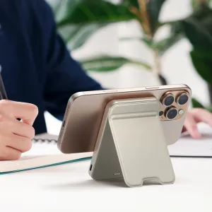 Satechi OntheGo Qi2 magnetisk powerbank med stativ, som holder en gullfarget smarttelefon oppe under lading