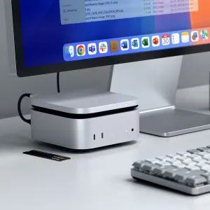 Satechi USB4 Slim NVMe SSD enclosure in silver on a desk beside a Mac, with cable connected.