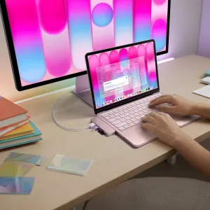 Satechi USB-C Snap Hub piestiprināts pie rozā MacBook, pievienojot uz galda kompaktu 6-in-1 USB-C centrmezgla paplašinājumu.