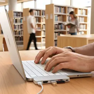 Satechi USB-C Snap Hub piestiprināts pie MacBook, ar HDMI, SD kartes slotu un USB-C caurlaides uzlādi