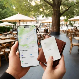 Satechi FindAll Geldbörsenkarte mit Apple „Wo ist?“-App auf dem iPhone, neben einer Ledergeldbörse abgebildet