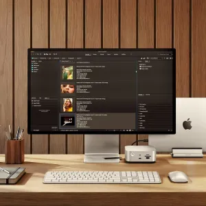Satechi desktop darbvieta ar monitoru, tastatūru un USB-C centrmezglu blakus Apple datoram.