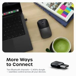 Satechi Slim EX trådløs mus i svart med USB-C-dongle ved siden av en bærbar PC på et skrivebord
