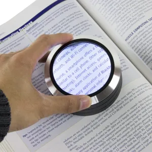 Lupa LED Satechi Read Mate 5x sobre un libro abierto, ampliando el texto impreso pequeño para facilitar la lectura