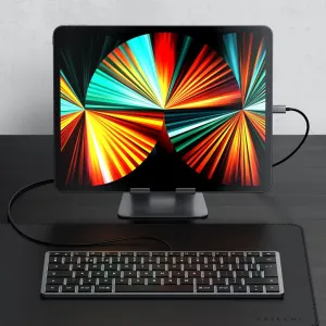 Satechi W1 USB-C-tangentbord med nordisk layout, visas anslutet med kabel bredvid en surfplatta på ett skrivbord