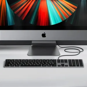 Satechi W3 USB-C-tangentbord med numerisk knappsats och silverfärgad ram på ett skrivbord bredvid en stationär Apple-dator