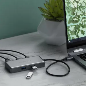 Satechi USB-C-moniporttisovitin tähtiharmaana liitettynä kannettavaan tietokoneeseen, johon on kytketty USB-muistitikku ja kaapeleita