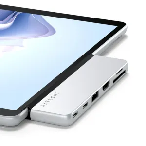 Satechi hopeanvärinen kahden USB-C-liitännän keskitin Surface Pro 9 -tablettiin kiinnitettynä, laajentaen liitettävyyttä lisäporteilla