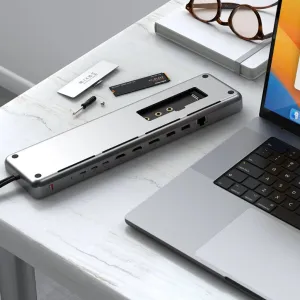 Satechi USB-C -kaksoistelakka työpöydällä kannettavan tietokoneen vieressä, jossa on HDMI-, Ethernet- ja SSD-laajennusportit