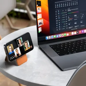 Satechi magnetisk lommebokstativ som holder en smarttelefon oppe ved siden av en bærbar PC for håndfri visning og videosamtaler.