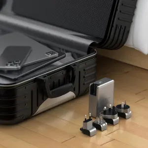 Satechi 145 W USB-C-matkalaturi vaihdettavilla pistokesovittimilla avoimen matkalaukun vieressä