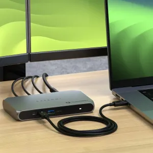 Satechi Thunderbolt 4 -keskitin työpöydällä kannettavaan tietokoneeseen liitettynä, taustalla näyttöjä