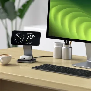 Soporte de carga Qi2 plegable 2 en 1 de Satechi con iPhone en horizontal y estuche de AirPods sobre el escritorio