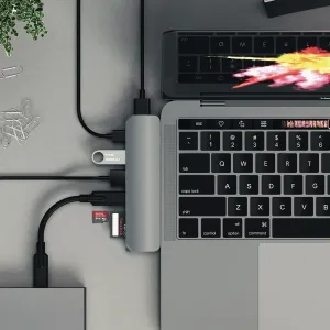 Prie nešiojamojo kompiuterio prijungtas Satechi USB-C Pro Hub su prijungta USB atmintine ir atminties kortele
