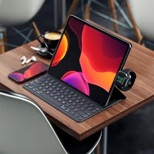 Satechi USB-C Magnetic Charging Dock lader en Apple Watch ved siden av et tastaturdeksel til nettbrett