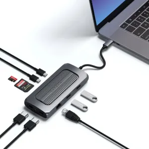 Satechi USB-C -moniporttisovitin avaruusharmaana, kiinteällä kaapelilla sekä Ethernet- ja USB-porteilla, kuvassa kannettavan tietokoneen lisävarusteiden kanssa.
