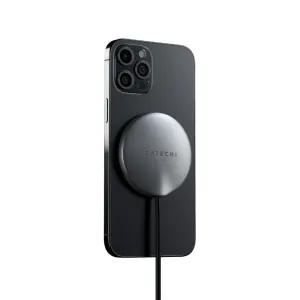 Cable de carga inalámbrica magnética Satechi adherido a la parte trasera de un iPhone, con un disco de carga gris espacial.