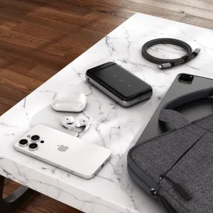 Satechi Duo Wireless Charger Stand lataamassa puhelinta pystyasennossa, nappikuulokkeet ja toinen puhelin pöydällä