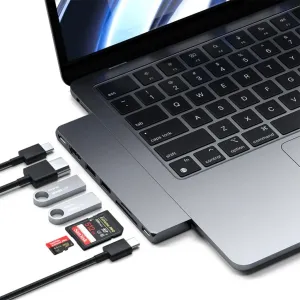 Satechi USB-C Pro Hub Slim kiinnitettynä MacBookiin, USB-C-liitännöillä ja tallennusta varten tarkoitetuilla muistikorteilla.