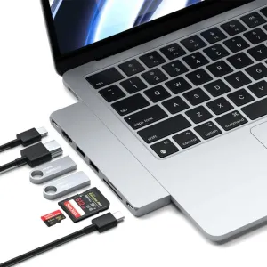Satechi USB-C Pro Hub Slim šalia sidabrinio MacBook, su USB-C laidais ir atminties kortelėmis plėtrai.