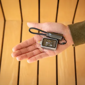 Satechi mini NVMe SSD -kotelo läpinäkyvällä kannella ja asennetulla SSD-levyllä, kuvattuna kädessä lenkkihihnan kanssa