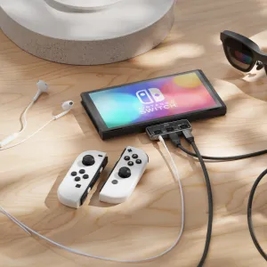Satechi Mobile XR Hub yhdistettynä Nintendo Switchiin, kaapeleiden ja langallisten nappikuulokkeiden kanssa puisella pöytätasolla
