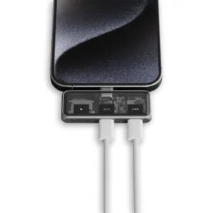 Satechi USB-C-keskitin älypuhelimeen kiinnitettynä, läpinäkyvä yläosa, 100 W -merkintä ja kaksi kaapelia.