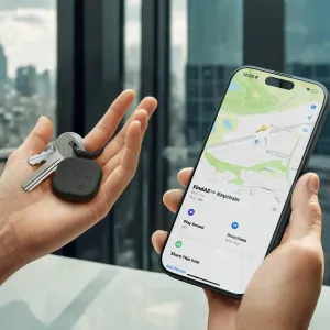Vegaaninahkainen Satechi FindAll Find My -avaimenperä avaimiin kiinnitettynä iPhonen vieressä, jonka näytöllä näkyy paikannus.