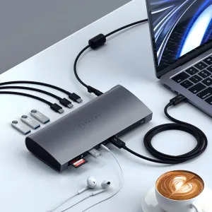Satechi Thunderbolt 4 -telakka liitettynä kannettavaan tietokoneeseen työpöydällä, vieressä kaapeleita, USB-asemia ja muistikortteja.