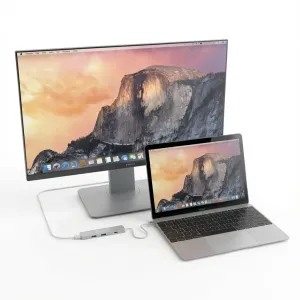 Satechi Slim USB-C -moniporttinen sovitin kytkettynä kannettavaan tietokoneeseen ja ulkoiseen näyttöön, USB-A-portit näkyvissä.