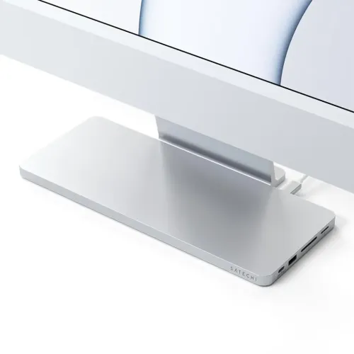 Satechi USB-C Slim Dock in silver with low profile under iMac stand, connected via cable, with USB-C, USB-A and SD/microSD ports.