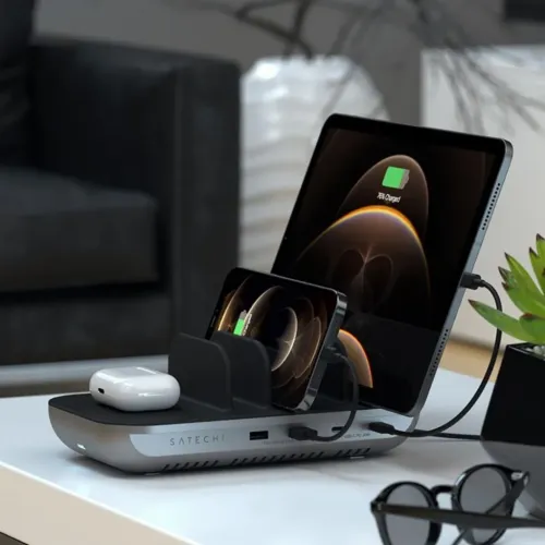 Satechi Dock5 charging station in gray on table with stand and Qi plate, visible ports at the front, charges tablet, phone.