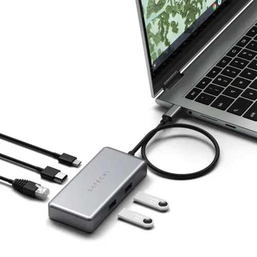 Rumgrå USB-C-multiportadapter tilsluttet en bærbar computer med to synlige USB-A-porte samt kabler og to USB-sticks ved siden af.
