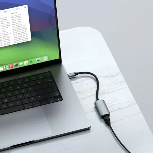 Satechi USB-C til Ethernet-adapter i aluminium med flettet kabel, som kobles mellom den bærbare datamaskinens USB-C og en RJ45-kabel for bordbruk.