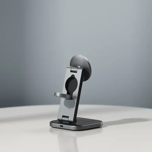 Satechi 3-i-1 sammenleggbart ladestativ i metall på bordet, med rund magnetisk plate, fordypning for klokkepuck, liten hylle og USB-C-port i basen.
