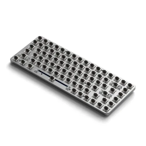 Lysegråt, slankt tastatur med synlige lavprofilkontakter og stabilisatorer, afrundede hjørner og let vinklet profil, set på skrå.