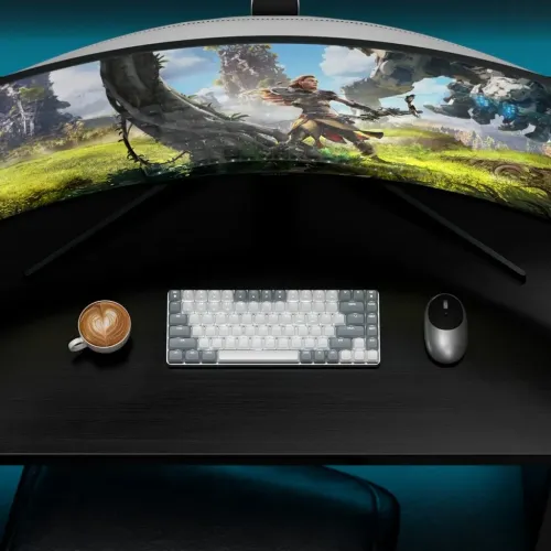 Satechi mekanisk lysegråt tastatur med hvidgrå taster på sort bordplade, mus til højre og en kop til venstre.