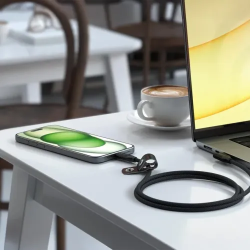 "Satechi" stačiakampis pintas USB-C kabelis, jungiamas tarp išmaniojo telefono ir nešiojamojo kompiuterio ant stalo, suvyniotas su kabelio laikikliu.