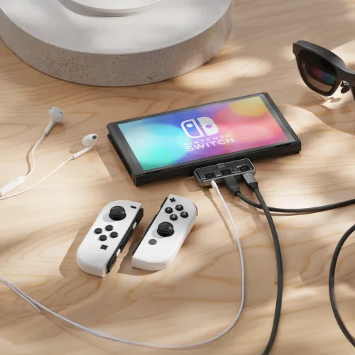 Satechi Mobile XR Hub tilsluttet en Nintendo Switch med kabler og kablede øretelefoner på en træbordplade