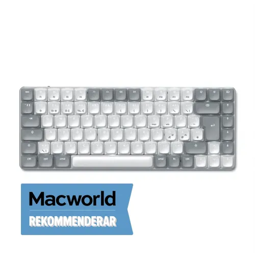 Ljusgrått, kompakt tangentbord upplyst i vitt, toppvy av funktionsrad och piltangenter; Macworld rekommenderar-märke nedtill.
