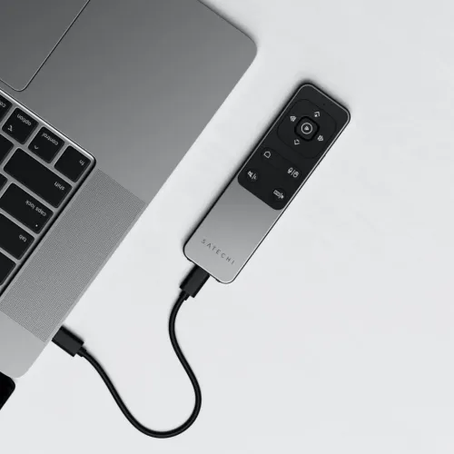 Satechi R2-fjernkontroll i metall med styreflate og medieknapper, koblet til den bærbare datamaskinen med USB-C-kabel, sett ovenfra.