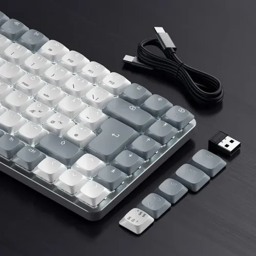 Satechi SM1 Slim ljusgrått mekaniskt tangentbord med vit bakbelysning, med USB‑C‑kabel, USB‑dongel och extra lösa tangenter.