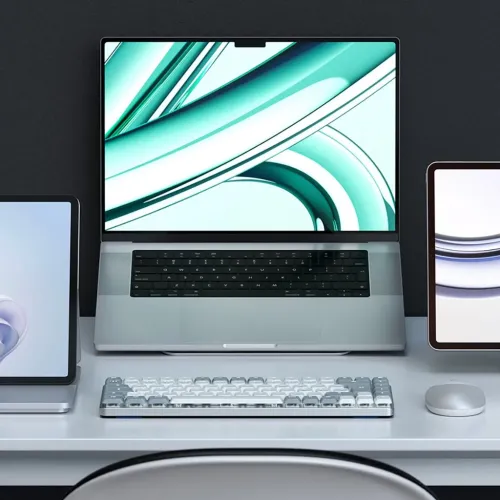 Satechi SM1 ljusgrått mekaniskt tangentbord med vita och grå tangenter, låg profil, på skrivbord framför laptop och mus.