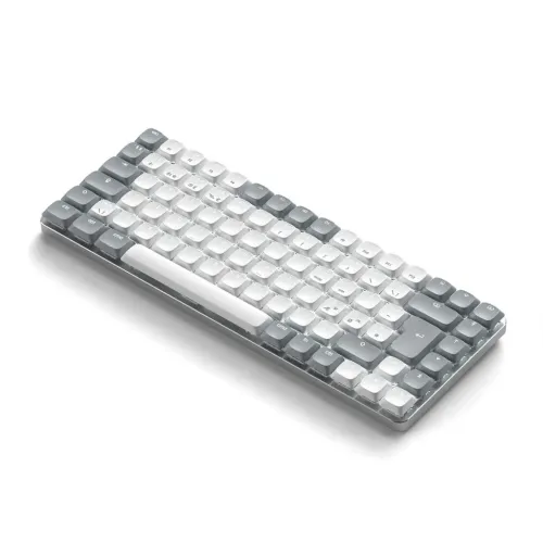 Kompakt tangentbord i ljusgrått och vitt med låg profil och rundade tangenter, visat i sned vinkel uppifrån med smal ram.