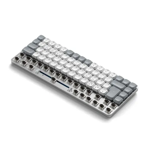 Satechi SM1 slimmat ljusgrått tangentbord, vita och grå tangenter; nedre raden utan tangenter visar synliga brytare i vinkel.