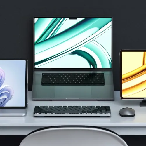 Satechi SM1 slim mekaniskt bakgrundsbelyst tangentbord i mörkgrått på skrivbord, kompakt låg profil framför bärbar dator.