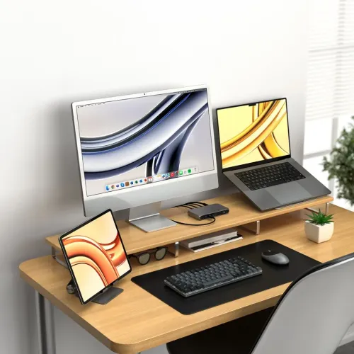 Satechi SM1 slim mörkgrått mekaniskt tangentbord med vit bakgrundsbelysning på svart skrivmatta framför skärm och laptop.